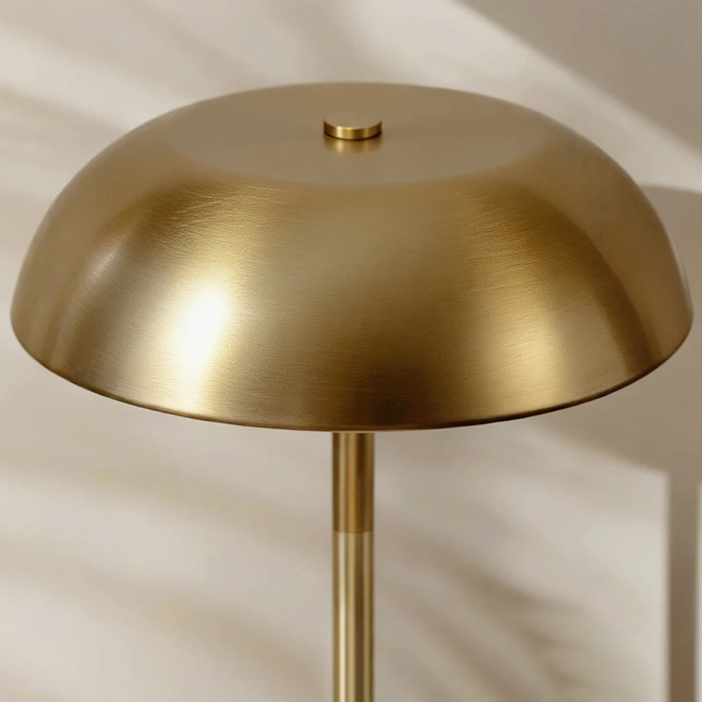 Compact, wireless brass mushroom-style task light with a circular base, ideal for a clutter-free and architectural home office or nightstand.