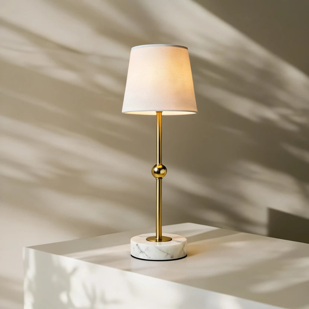 Rechargeable marble and brass table lamp with soft linen shade, bringing tactile luxury and warm illumination to a modern bedroom sanctuary.