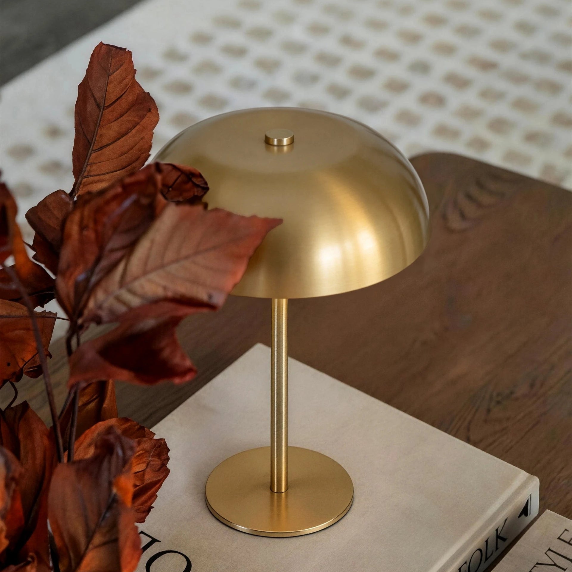A minimalist brass cordless lamp as a versatile sculptural element, adding quiet modern luxury to an entryway console table.