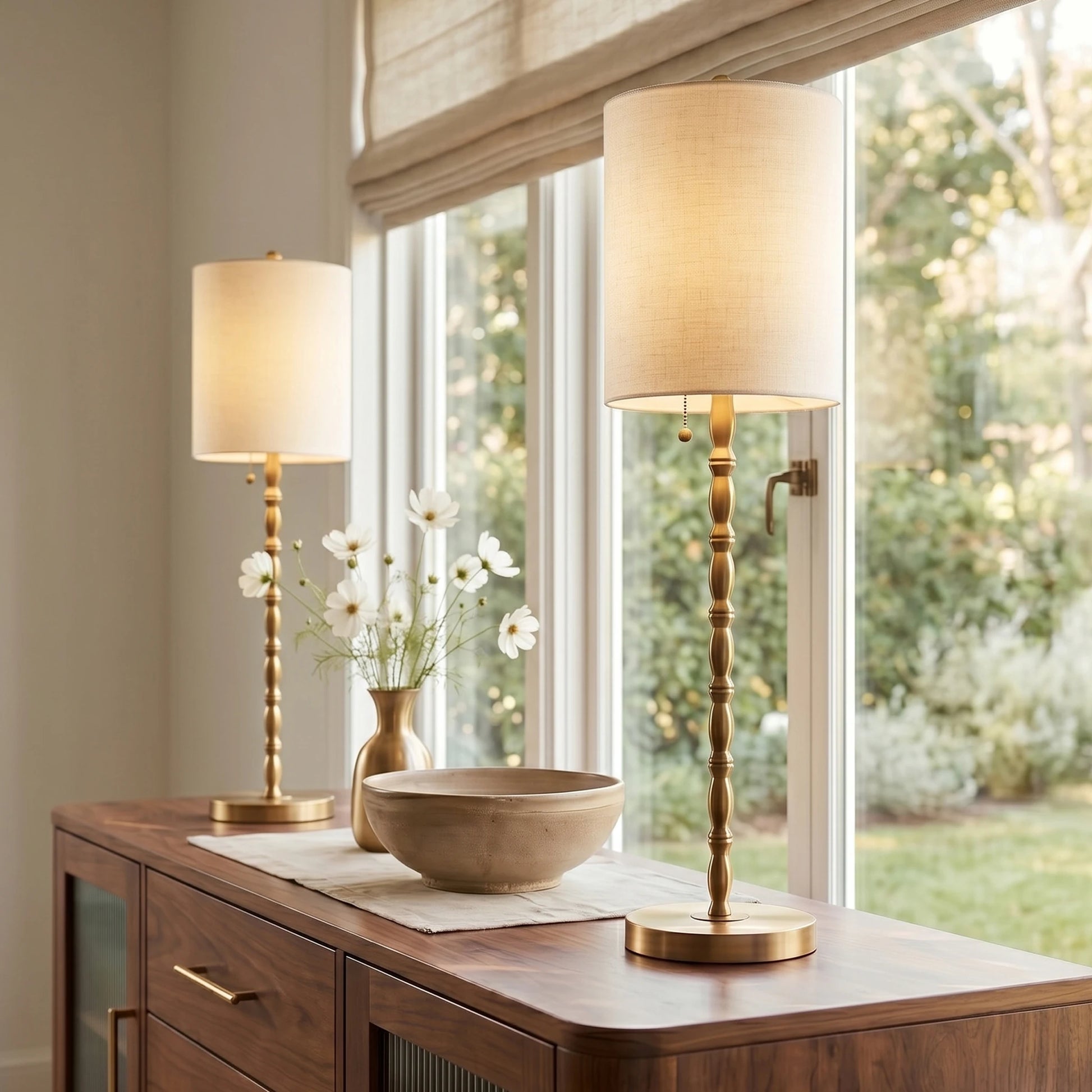 A symmetrical pair of tall brass buffet lamps framing an entryway console mirror, showcasing architectural elegance and sophisticated interior staging.