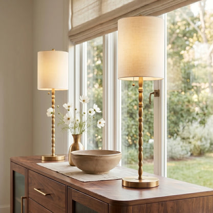 A symmetrical pair of tall brass buffet lamps framing an entryway console mirror, showcasing architectural elegance and sophisticated interior staging.